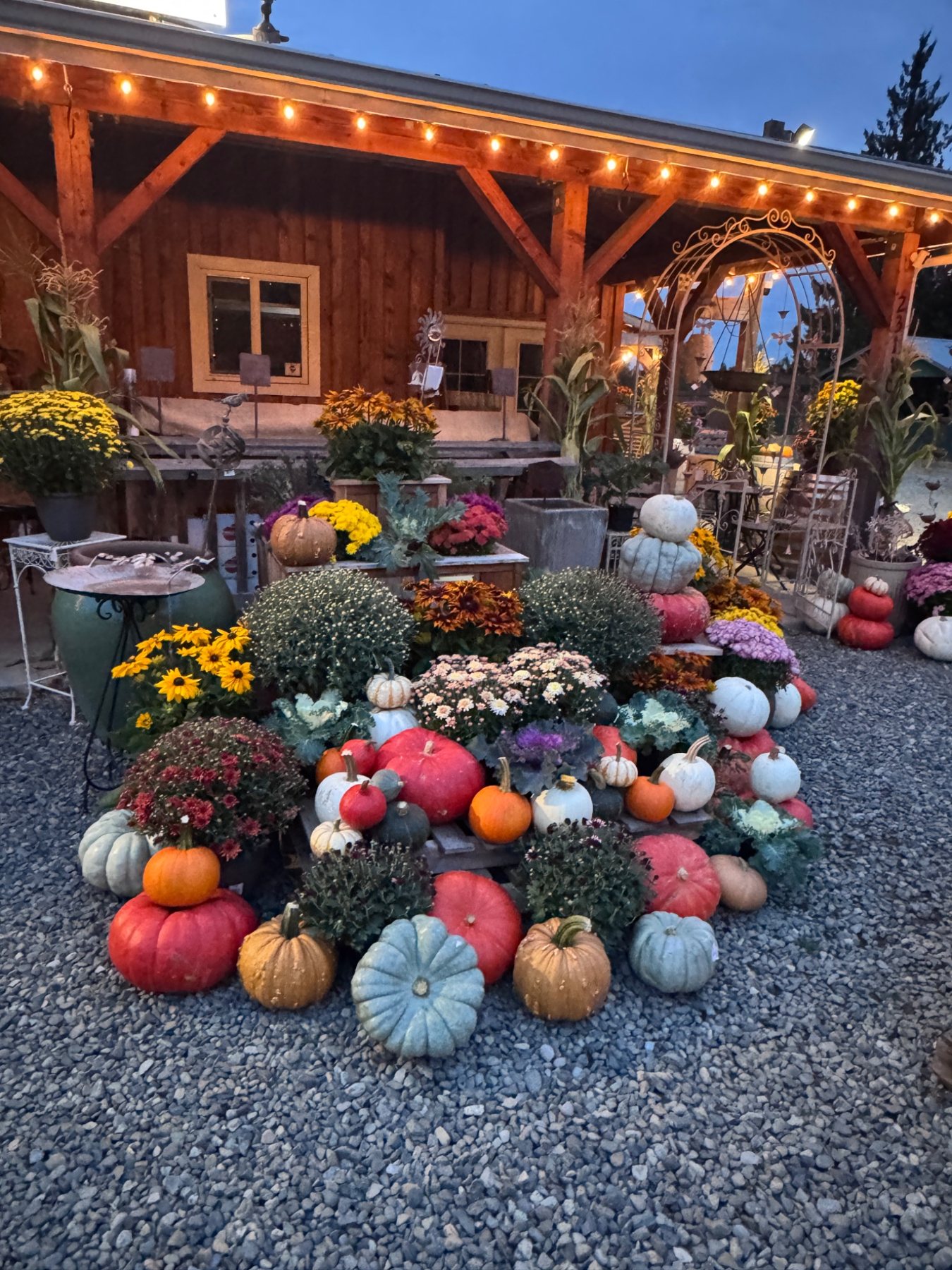 Colorful heirloom pumpkins, mums, and fall flowers outside Sweet Pea’s Mercantile